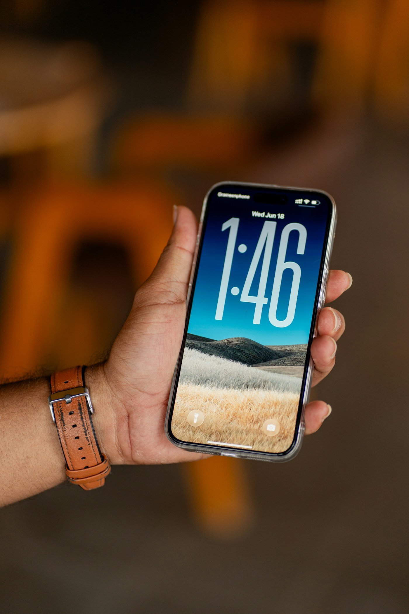 Hand holding an iPhone showing the lock screen